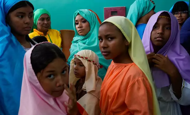 Devotees dressed as townspeople prepare to enter the stage to perform in a Way of the Cross reenactment in Arraijan, Panama, Friday, April 3, 2026. (AP Photo/Matias Delacroix)