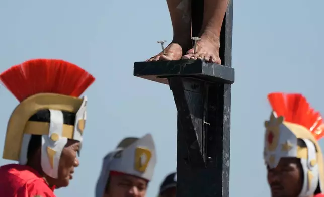 A nail is pierced on the feet of Arnold Manaigo during the reenactment of Jesus Christ's sufferings as part of Good Friday rituals in the San Pedro Cutud village, Pampanga province, northern Philippines April 3, 2026. (AP Photo/Aaron Favila)