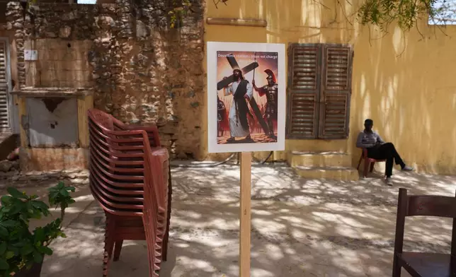 A poster promoting a Passion of Christ reenactment is displayed in the courtyard of Saint Charles church on Goree Island, Senegal, Friday, April 3, 2026. (AP Photo/Misper Apawu)