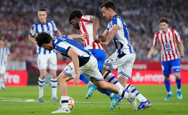 Real Sociedad's Jon Aramburu, left, and Mikel Oyarzabal, centre right, challenge for the ball with Atletico Madrid's Ademola Lookman during the Copa del Rey final soccer match between Atletico Madrid and Real Sociedad in Seville, Spain, Saturday, April. 18, 2026. (AP Photo/Jose Breton)