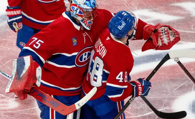 Montreal Canadiens goaltender Jakub Dobes (75) congratulates teammate Lane Hutson (48) after Hutson's winning goal against the Tampa Bay Lightning following overtime of Game 3 in a first-round NHL hockey Stanley Cup playoff series in Montreal, Friday, April 24, 2026. (Christinne Muschi/The Canadian Press via AP)