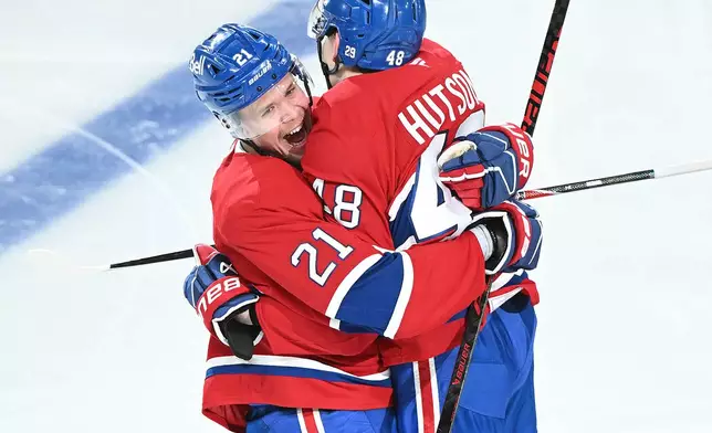 Montreal Canadiens' Lane Hutson (48) celebrates with teammate Kaiden Kuhle (21) after scoring against the Tampa Bay Lightning during overtime of Game 3 in a first-round NHL hockey Stanley Cup playoff series in Montreal, Friday, April 24, 2026. (Graham Hughes/The Canadian Press via AP)