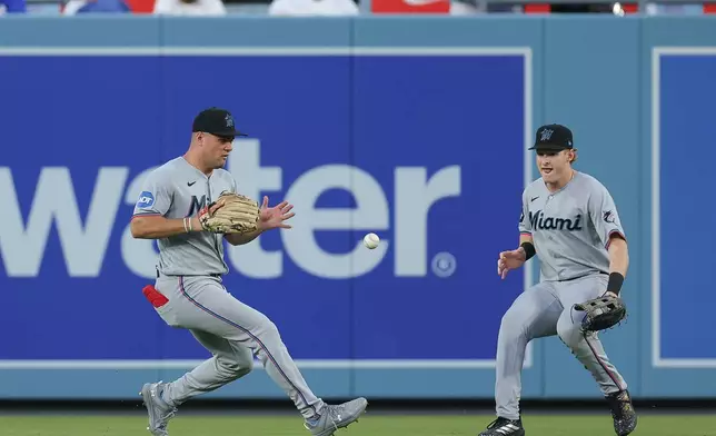 Miami Marlins center fielder Jakob Marsee, left, fields a single hit by Los Angeles Dodgers' Freddie Freeman during the first inning of a baseball game Monday, April 27, 2026, in Los Angeles. (AP Photo/Ryan Sun)