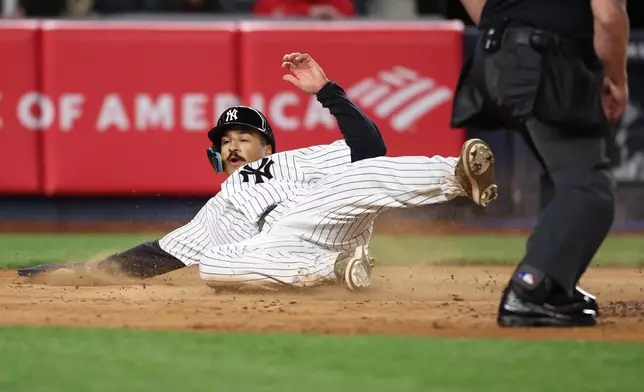 New York Yankees' Trent Grisham slides home to score during the sixth inning of a baseball game against the Miami Marlins, Saturday, April 4, 2026, in New York. (AP Photo/Heather Khalifa)