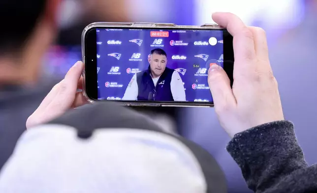 New England Patriots head coach Mike Vrabel, displayed on a mobile phone, speaks during an NFL football press conference, Tuesday, April 21, 2026, in Foxborough, Mass. (AP Photo/Mark Stockwell)