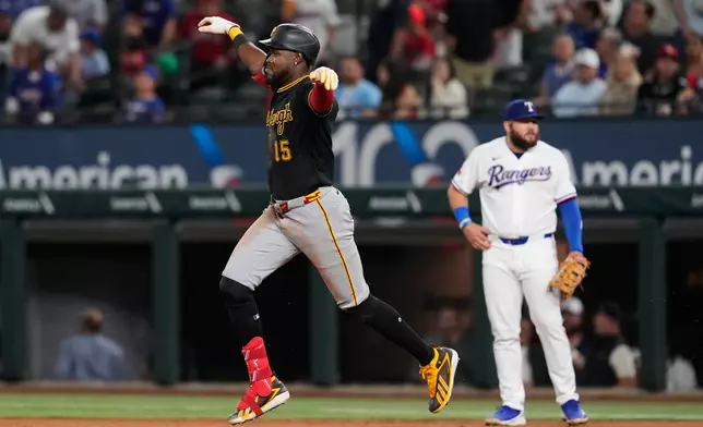 Pittsburgh Pirates' Oneil Cruz (15) celebrates his three-run home run as he rounds first past Texas Rangers' Jake Burger, rear, in the ninth inning of a baseball game Wednesday, April 22, 2026, in Arlington, Texas. (AP Photo/Tony Gutierrez)