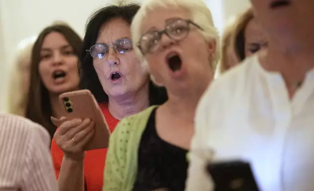 Choir members perform a song during a practice in Belgrade, Serbia, Wednesday, April 15, 2026. (AP Photo/Darko Vojinovic)