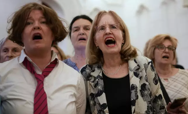 Choir members perform a song during a practice in Belgrade, Serbia, Wednesday, April 15, 2026. (AP Photo/Darko Vojinovic)
