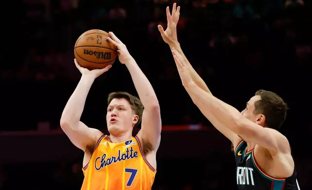 Charlotte Hornets guard Kon Knueppel (7) looks to shoot against Detroit Pistons forward Duncan Robinson, right, during the first half of an NBA basketball game in Charlotte, N.C., Friday, April 10, 2026. (AP Photo/Nell Redmond)