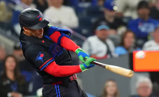 Toronto Blue Jays designated hitter George Springer hits an RBI double against the Minnesota Twins during sixth-inning baseball game action in Toronto, Friday, April 10, 2026. (Chris Young/The Canadian Press via AP)