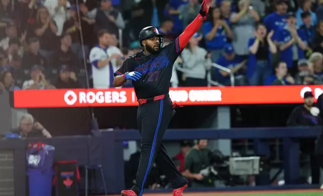 Toronto Blue Jays' Vladimir Guerrero Jr. celebrates as he scores against the Minnesota Twins during fourth-inning baseball game action in Toronto, Friday, April 10, 2026. (Chris Young/The Canadian Press via AP)
