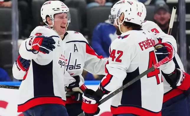Washington Capitals' Ryan Leonard (left) and Martin Fehervary (42) celebrate a goal against the Toronto Maple Leafs with teammates during second period NHL hockey action in Toronto on Wednesday, April 8, 2026. (Frank Gunn/The Canadian Press via AP)