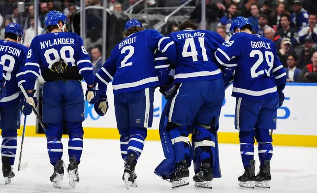 Toronto Maple Leafs goaltender Anthony Stolarz (41) is helped off the ice by teammates following an injury against the Washington Capitals during the first period of an NHL hockey game in Toronto on Wednesday, April 8, 2026. (Frank Gunn/The Canadian Press via AP)
