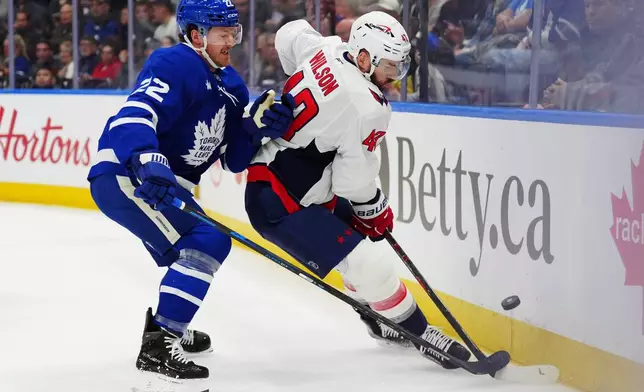 Toronto Maple Leafs' Jake McCabe (22) checks Washington Capitals' Tom Wilson (43) during first period NHL hockey action in Toronto on Wednesday, April 8, 2026. (Frank Gunn/The Canadian Press via AP)