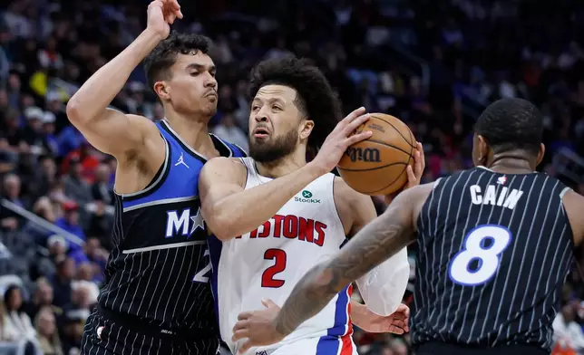 Detroit Pistons guard Cade Cunningham (2) goes to the basket between Orlando Magic forward Tristan da Silva (23) and forward Jamal Cain (8) during the first half in Game 5 of a first-round NBA basketball playoffs series Wednesday, April 29, 2026, in Detroit. (AP Photo/Duane Burleson)