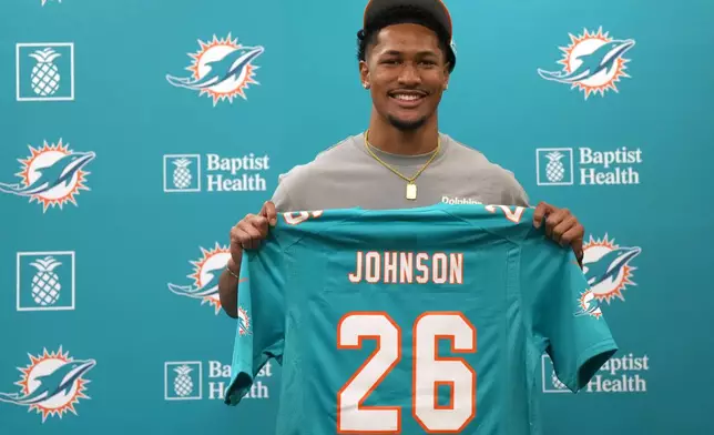 Miami Dolphins first-round draft pick Chris Johnson holds a jersey during an NFL football news conference, Friday, April 24, 2026, in Miami Gardens, Fla. (AP Photo/Jim Rassol)