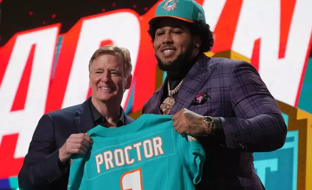 Alabama offensive lineman Kadyn Proctor poses with NFL Commissioner Roger Goodell after being chosen by the Miami Dolphins with the 12th overall pick during the first round of the NFL football draft, Thursday, April 23, 2026, in Pittsburgh. (AP Photo/Gene J. Puskar)