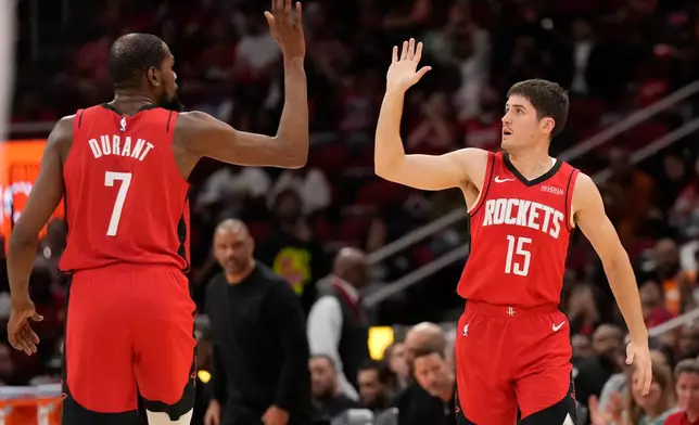 Houston Rockets' Kevin Durant (7) high-fives Reed Sheppard (15) after Sheppard's 3-point basket during the first half of an NBA basketball game against the Utah Jazz, Friday, April 3, 2026, in Houston. (AP Photo/Karen Warren)