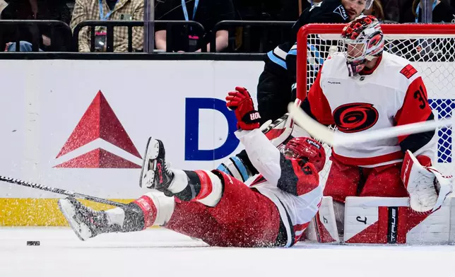 Carolina Hurricanes left wing Jordan Martinook, left, slides to block the puck during the first period of an NHL hockey game against the Utah Mammoth, Saturday, April 11, 2026, in Salt Lake City. (AP Photo/Tyler Tate)