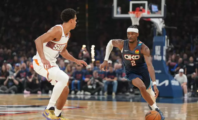 Oklahoma City Thunder guard Shai Gilgeous-Alexander, right, drives past Phoenix Suns forward Oso Ighodaro during the second half in Game 2 of a first-round NBA playoffs basketball series Wednesday, April 22, 2026, in Oklahoma City. (AP Photo/Kyle Phillips)