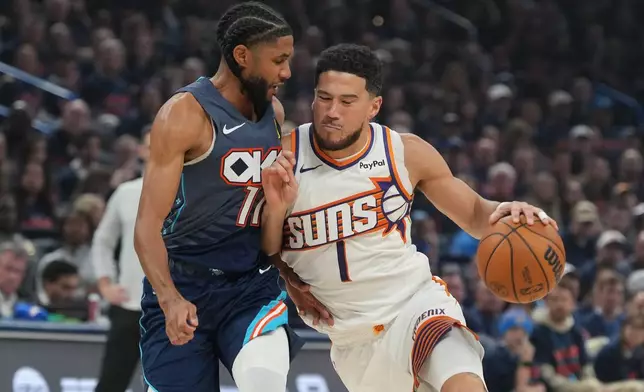 Phoenix Suns guard Devin Booker, right, srives past Oklahoma City Thunder guard Isaiah Joe during the first half in Game 2 of a first-round NBA playoffs basketball series Wednesday, April 22, 2026, in Oklahoma City. (AP Photo/Kyle Phillips)
