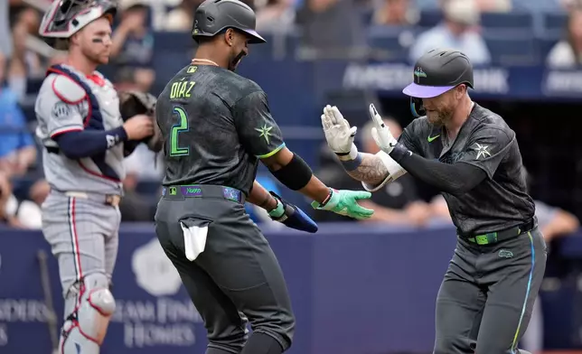 Tampa Bay Rays' Jake Fraley celebrates with Yandy Díaz (2) after Fraley hit a two-run home run off Minnesota Twins pitcher Bailey Ober during the fourth inning of a baseball game Saturday, April 25, 2026, in St. Petersburg, Fla. (AP Photo/Chris O'Meara)