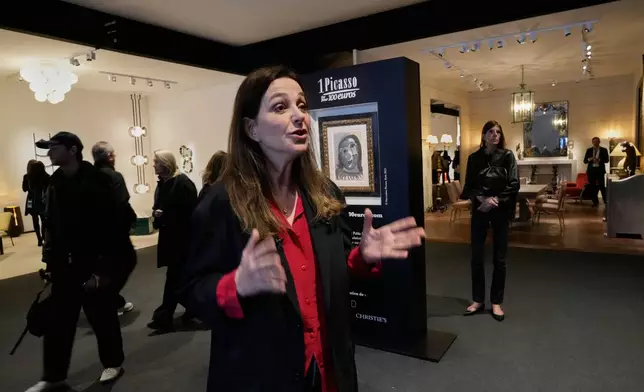 Peri Cochin, co-founder of the "1 Picasso for 100 euros" lottery, speaks during an Associated Press interview, next to Head of a Woman by Pablo Picasso, painted in 1941, in Paris, Friday, April 10, 2026, where the draw will be handled by auction house Christie's next week. (AP Photo/Michel Euler)