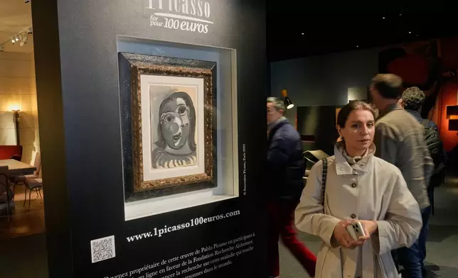 People walks past the Head of a Woman by Pablo Picasso, painted in 1941, in Paris, Friday, April 10, 2026, where the draw will be handled by auction house Christie's next week. (AP Photo/Michel Euler)