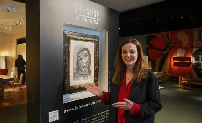 Peri Cochin, co-founder of the "1 Picasso for 100 euros" lottery, poses next to Head of a Woman by Pablo Picasso, painted in 1941, in Paris, Friday, April 10, 2026, where the draw will be handled by auction house Christie's next week. (AP Photo/Michel Euler)