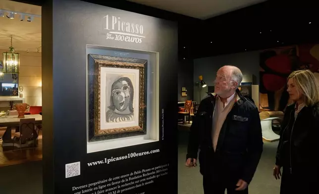 People look at the Head of a Woman by Pablo Picasso, painted in 1941, in Paris, Friday, April 10, 2026, where the draw will be handled by auction house Christie's next week. (AP Photo/Michel Euler)