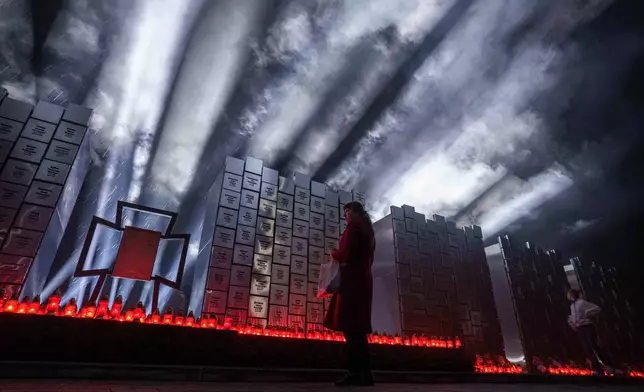 A woman attends a ceremony at a memorial for killed civilians to mark the fourth anniversary of the liberation of Bucha, Ukraine, on Monday, March 30, 2026. (AP Photo/Evgeniy Maloletka)