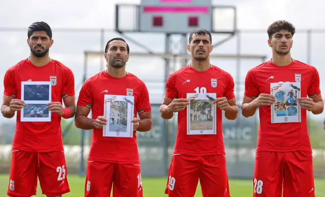 Iran's players sing the national anthem, holding pictures of children allegedly killed in U.S. and Israel strikes in Iran, before a friendly soccer match between Iran and Costa Rica, in Antalya, southern Turkey, Tuesday, March 31, 2026. (AP Photo/Riza Ozel)
