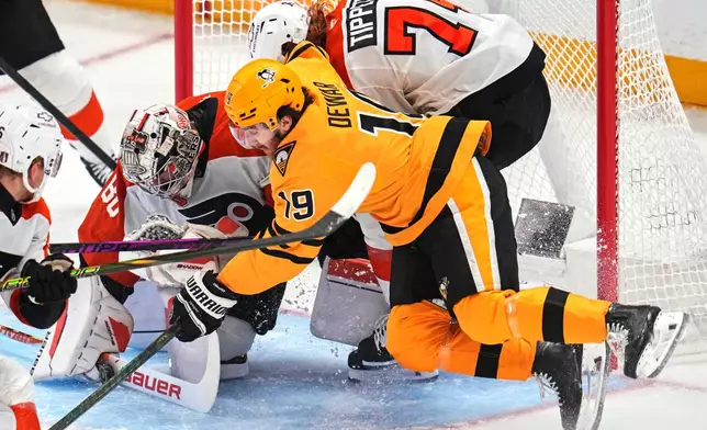 Philadelphia Flyers goaltender Dan Vladar (80) blocks shot with teammate Owen Tippett (74) defending against Pittsburgh Penguins' Connor Dewar (19) during the first period of Game 5 in the first round of an NHL hockey Stanley Cup playoff series in Pittsburgh, Monday, April 27, 2026. (AP Photo/Gene J. Puskar)