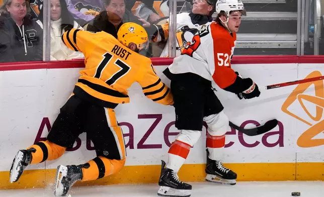 Pittsburgh Penguins' Bryan Rust (17) collides with Philadelphia Flyers' Denver Barkey (52) during the first period of Game 5 in the first round of an NHL hockey Stanley Cup playoff series in Pittsburgh, Monday, April 27, 2026. (AP Photo/Gene J. Puskar)