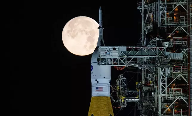 FILE - A full moon is seen shining over NASA's SLS (Space Launch System) and Orion spacecraft atop the mobile launcher in the early hours of Feb. 1, 2026, at NASA's Kennedy Space Center in Florida. (Sam Lott/NASA via AP, File)