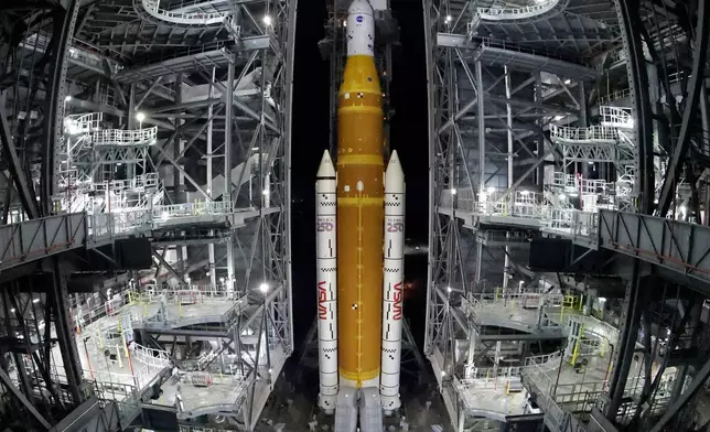 FILE - The NASA Artemis II rocket, with the Orion spacecraft aboard, leaves the Vehicle Assembly Building at the Kennedy Space Center in Cape Canaveral, Fla., March 20, 2026. (AP Photo/Terry Renna, File)