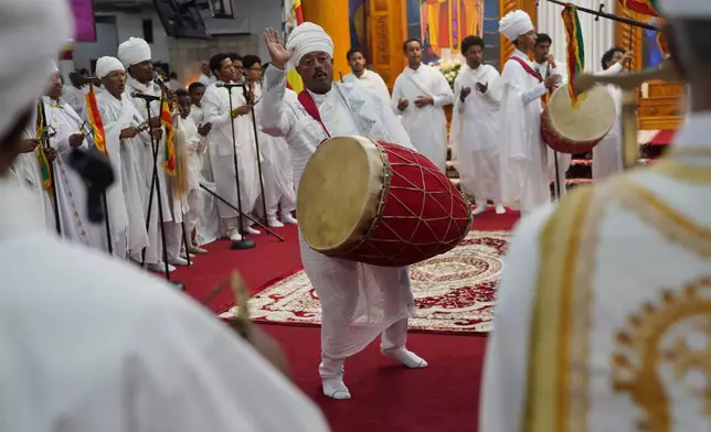 Deacon Tassew Yinadu, center plays the drum, or kebero, during Easter service at Re'ese Adbarat Debre Selam Kidist Mariam Church, an Ethiopian Orthodox Tewahedo church, in Washington, Saturday, April 11, 2026. (AP Photo/Jessie Wardarski)