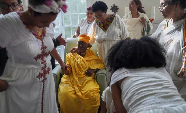 The Tekola family gathers for a feast to celebrate Easter, or Fasika in Amharic, and break their 55-day fasting period, Sunday, April 12, 2026, in Triangle, Va. (AP Photo/Jessie Wardarski)
