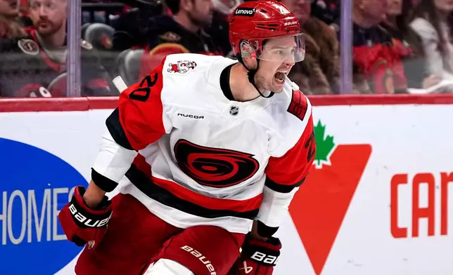 Carolina Hurricanes' Sebastian Aho (20) celebrates scoring an empty net goal against the Ottawa Senators in the third period in Game 4 of a first-round NHL Stanley Cup playoff hockey series, Saturday, April 25, 2026, in Ottawa, Ontario. (Justin Tang/The Canadian Press via AP)