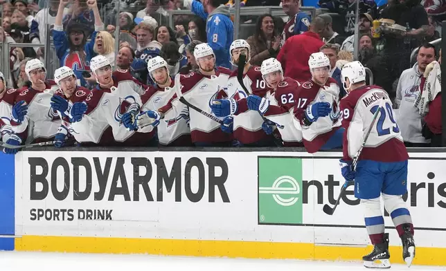 The Colorado Avalanche's bench greets Nathan MacKinnon (29) after MacKinnon's goal against the Los Angeles Kings during the first period of Game 4 in the first round of an NHL hockey Stanley Cup playoff series Sunday, April 26, 2026, in Los Angeles. (AP Photo/Scott Strazzante)