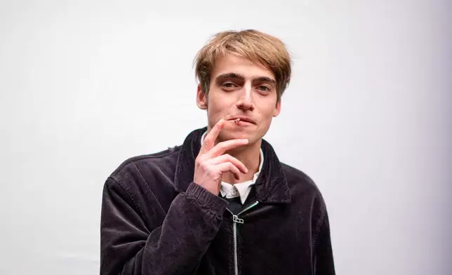 Gusztav Komaromy, 22, poses for a portrait as he smokes a cigarette in Budapest, Hungary, Monday, April 13, 2026. "We had a regime that took control of our lives and political consciousness. We had to take a stance about propaganda, about political cynicism, about the state of the public sphere. " (AP Photo/Petr David Josek)