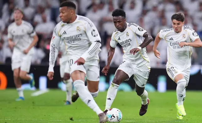 Real Madrid's Vinicius Junior, center, in action during a La Liga soccer match between Real Madrid and Alaves in Madrid, Spain, Tuesday, April 21, 2026. (AP Photo/Manu Fernandez)