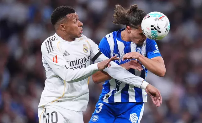 Real Madrid's Kylian Mbappe, left, and Alaves' Youssef Enriquez fight for the ball during a La Liga soccer match between Real Madrid and Alaves in Madrid, Spain, Tuesday, April 21, 2026. (AP Photo/Manu Fernandez)