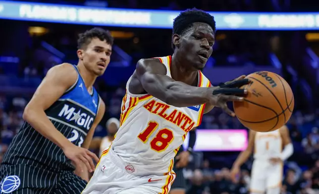 Atlanta Hawks forward Mouhamed Gueye (18) gains control of the ball as he is defended by Orlando Magic forward Tristan da Silva (23) during the first half of an NBA basketball game Wednesday, April 1, 2026, in Orlando, Fla. (AP Photo/Kevin Kolczynski)