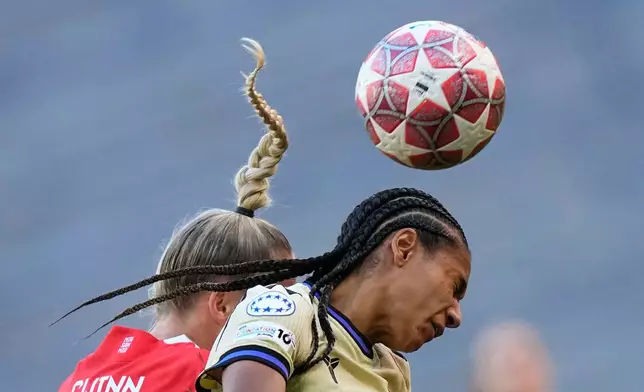Bayern's Giulia Gwinn, left, and Barcelona's Esmee Brugts go for a header during the Women's Champions League semifinal first leg soccer match between Bayern Munich and Barcelona in Munich, Germany, Saturday, April 25, 2026. (AP Photo/Matthias Schrader)