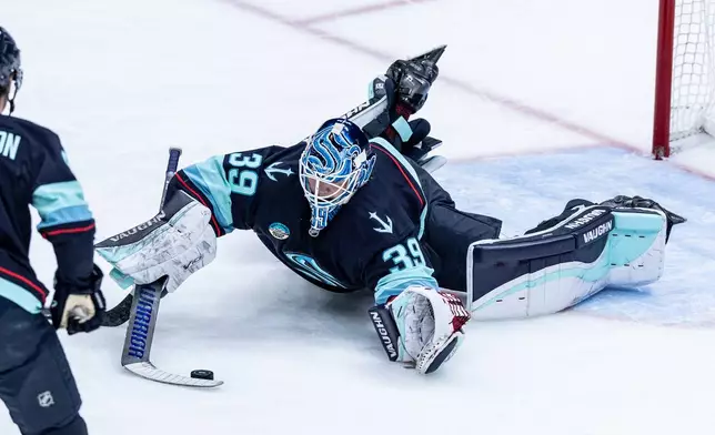 Seattle Kraken goaltender Nikke Kokko makes a save during the first period of an NHL hockey game against the Calgary Flames, Saturday, April 11, 2026, in Seattle. (AP Photo/Maddy Grassy)