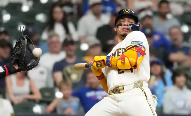 Milwaukee Brewers' William Contreras ducks to avoid being hit by a pitch during the seventh inning of a baseball game against the Toronto Blue Jays, Tuesday, April 14, 2026, in Milwaukee. (AP Photo/Aaron Gash)