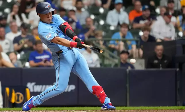 Toronto Blue Jays' Kazuma Okamoto hits an infield single during the seventh inning of a baseball game against the Milwaukee Brewers, Tuesday, April 14, 2026, in Milwaukee. (AP Photo/Aaron Gash)