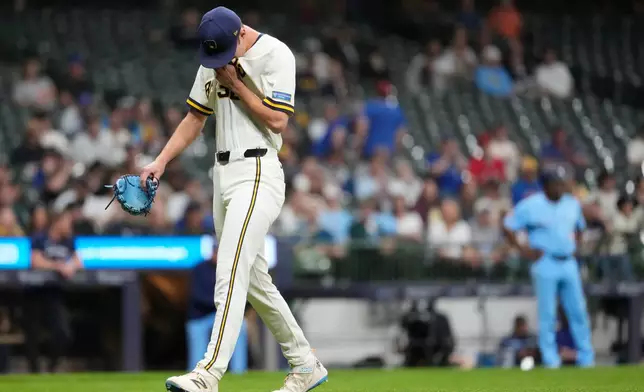 Milwaukee Brewers' Jacob Misiorowski wipes his face as he walks to the dugout after being removed during the sixth inning of a baseball game against the Toronto Blue Jays, Tuesday, April 14, 2026, in Milwaukee. (AP Photo/Aaron Gash)