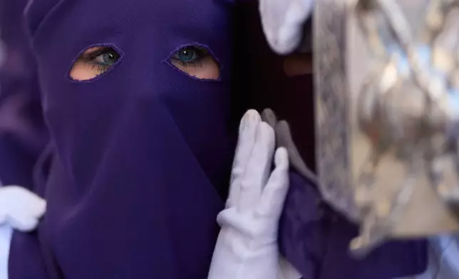 A hooded penitent of the Nuestro Padre Jesus del Huerto y San Diego brotherhood participates in a Holy Week procession in Baena, southern Spain, Wednesday, April 1, 2026. (AP Photo/Manu Fernandez)